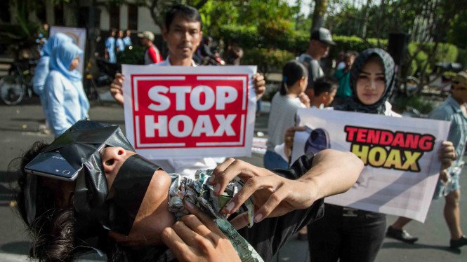 Warga melakukan aksi teatrikal saat mengkampanyekan Gerakan Anti Hoax di Solo, Jawa Tengah.
